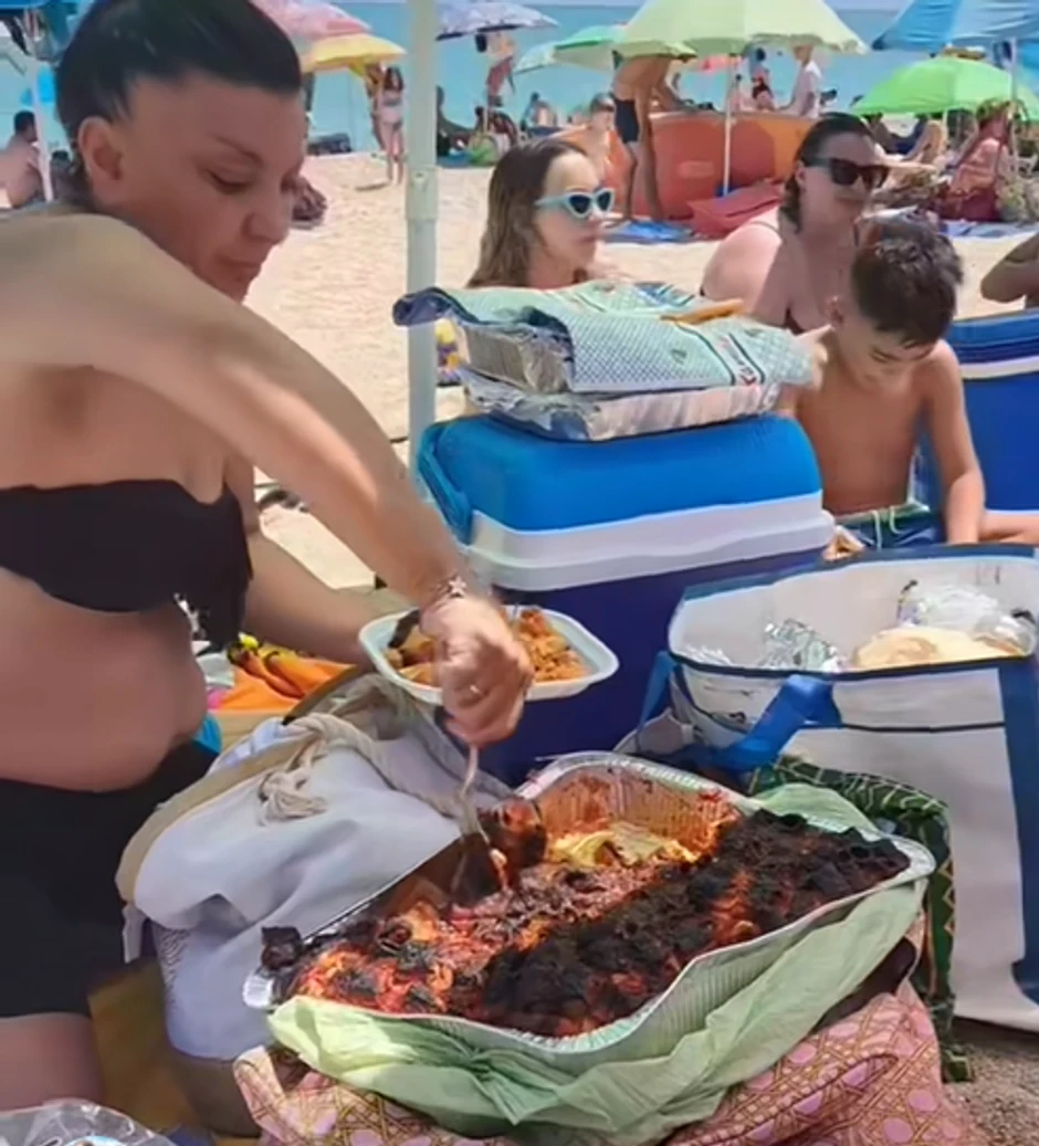 Porodica jede musaku na plaži