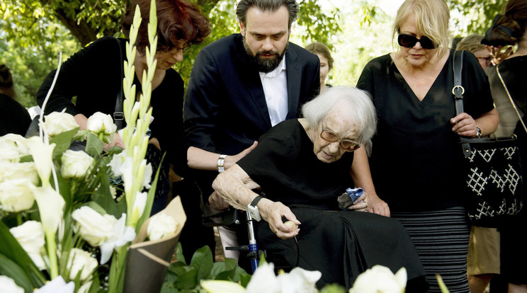 A kezében szorongatott rózsát a fia sírján lévő koszorúkhoz rakta/Fotó: MTI/Koszticsák Szilárd