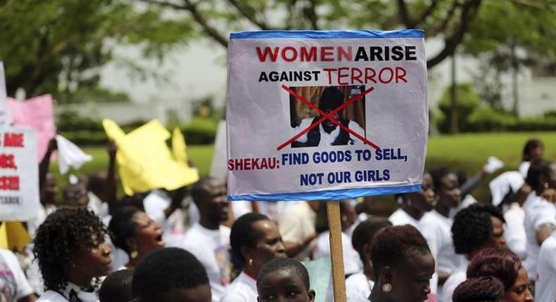 A student holds a sign with an image of Boko Haram leader?Abubakar?Shekau?as she protests for the release of the abducted secondary school girls in the remote village of Chibok, along a road in Lagos May 12, 2014. 