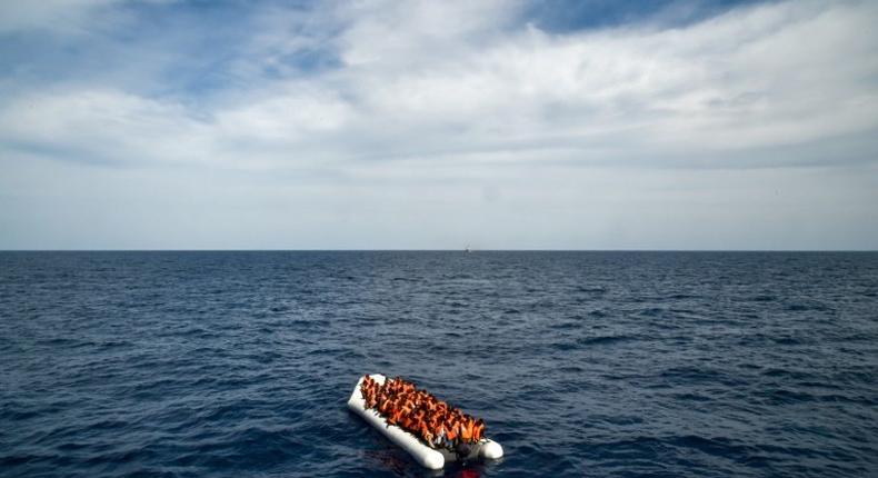 Migrants and refugees on a rubber boat wait to be evacuated on November 5, 2016 off the coast of Libya