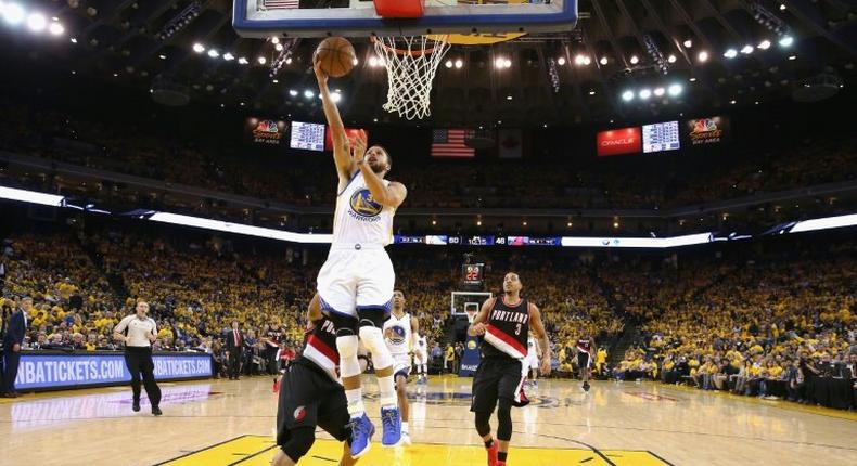 Stephen Curry of the Golden State Warriors goes up for a shot against Evan Turner of the Portland Trail Blazers in Game Two of the Western Conference Quarterfinals