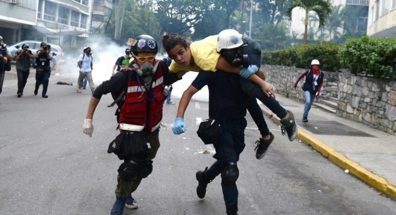 An injured opposition activist is taken away by volunteer medics during a protest against the government of President Nicolas Maduro in Caracas on July 1