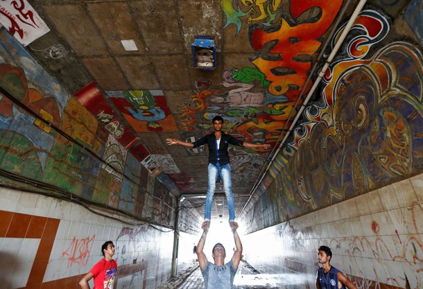 Members of an acrobatic group practice at a pedestrian underpass in Mumbai