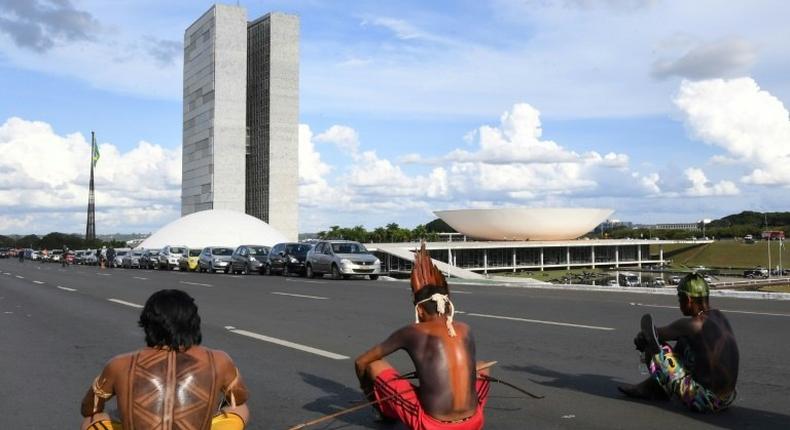 Brazilian indigenous people block a road as they sit in front of the National Congress during the annual march for their rights, in Brasilia, on April 25, 2017