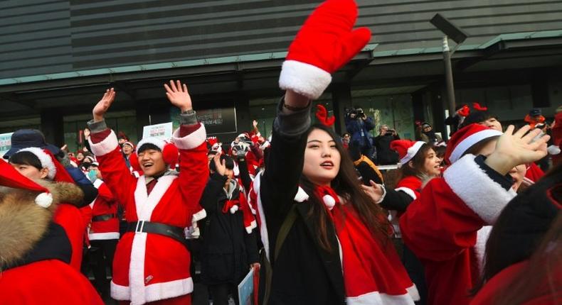 Protesters wearing Santa Claus outfits attend a rally calling for the immediate removal of South Korea's impeached president Park Geun-Hye in downtown Seoul on December 24, 2016