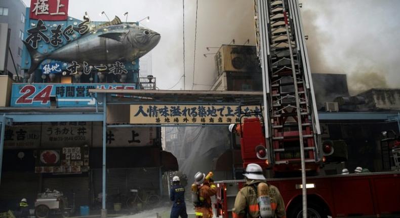 Japanese firefighters try to extinguish a fire at Tokyo's Tsukiji fish market on August 3, 2017