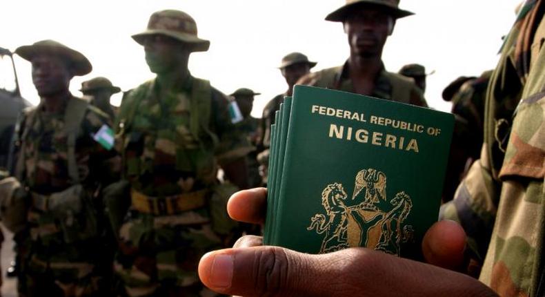 A Nigerian officer holds passports for his troops preparing to board a U.S. military plane in the Nigerian capital of Abuja