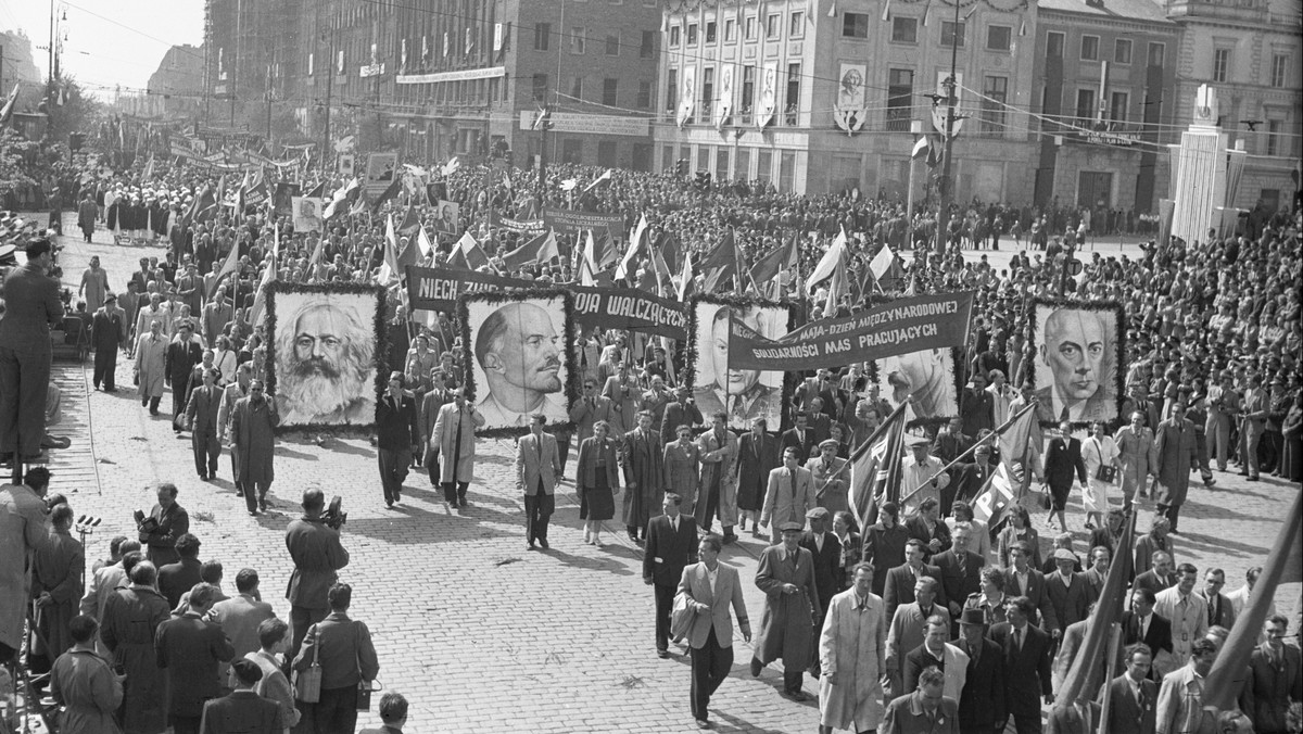 Warszawiacy z kwiatami, transparentami i flagami maszerują w pochodzie pierwszomajowym/ 1951 rok 