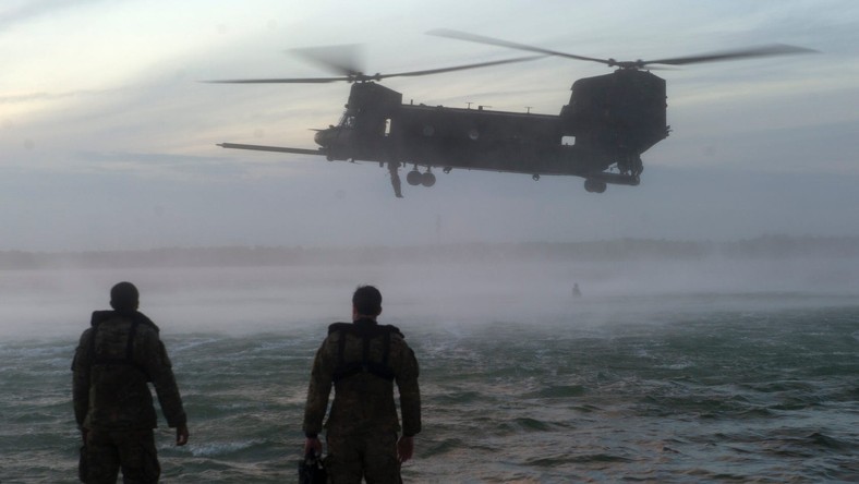 US Army 7th Special Forces Group (Airborne) Green Berets observe a CH-47 Chinook helicopter conduct hoisting operations during helocast training at Eglin Base Air Force Base, Florida, February 6, 2013. 