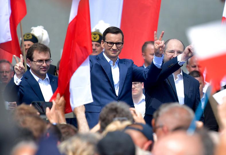 El mencionado mitin en Bocatinia.  En el escenario, desde la izquierda: Zbigniew Girzyński, el primer ministro Mateusz Morawiecki y el presidente del Partido Republicano, el eurodiputado Adam Bielan