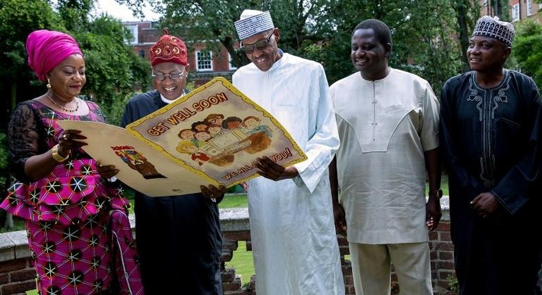 Buhari (centre) receives a giant Get Well card, in this handout photo taken on August 12 in London, where the Nigerian president has been receiving treatment for an undisclosed ailment for over three months