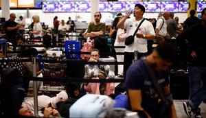 Passengers wait in the check in area of Gatwick Airport as some flights are cancelled or delayed caused by IT outages.BENJAMIN CREMEL/ Getty Images