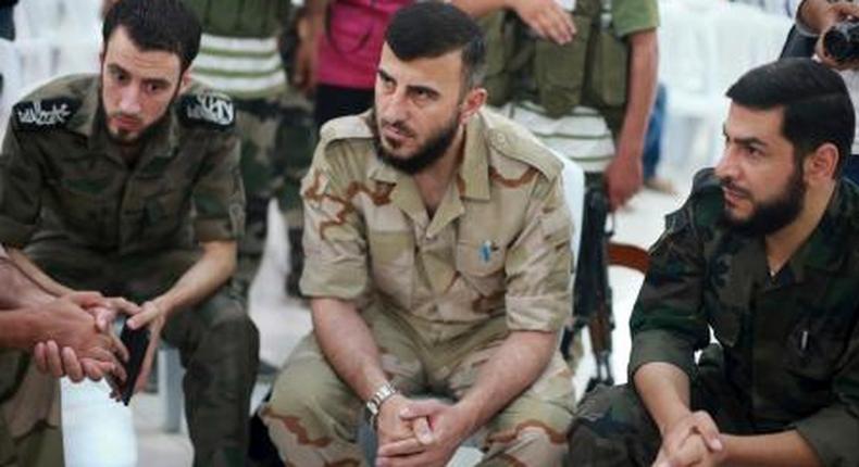 Zahran Alloush (C), commander of Jaysh al Islam, sits during a conference in the town of Douma, eastern Ghouta in Damascus, Syria August 27, 2014.