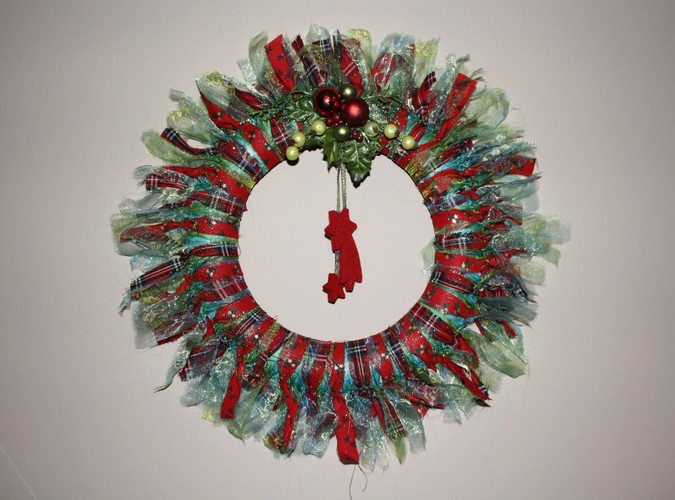 Świąteczny wianek z kolorowych szmatek, ozdobiony ministroikiem z małych bobek i wiszącymi gwiazdkami. Autorka: Marta Jarosińska-Mańka