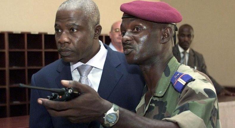 Former Ivory Coast Defense Minister Kadet Gahie Bertin (L) is assisted by a FANCI officer in this 2003 file photo.