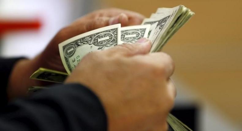 A customer counts his U.S. dollar notes in a bank in Cairo, Egypt March 10, 2016. REUTERS/Amr Abdallah Dalsh