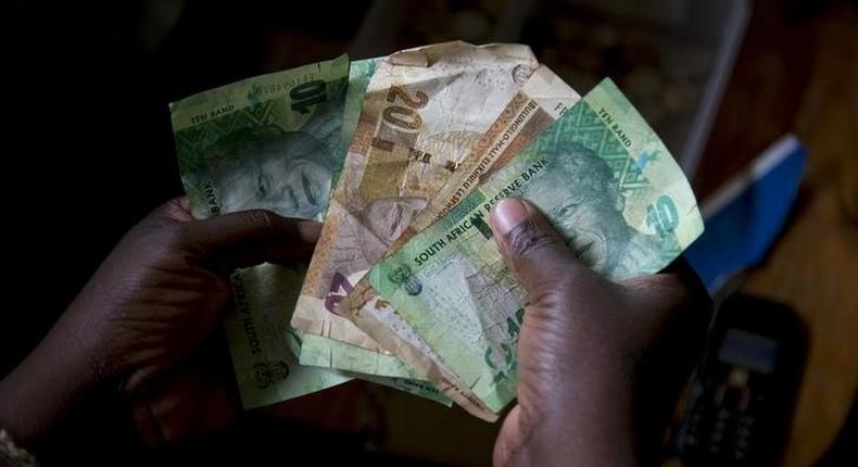 A shopkeeper counts out change above her cash box at her shop in Hillcrest, west of Durban, South Africa, January 11, 2016. REUTERS/Rogan Ward