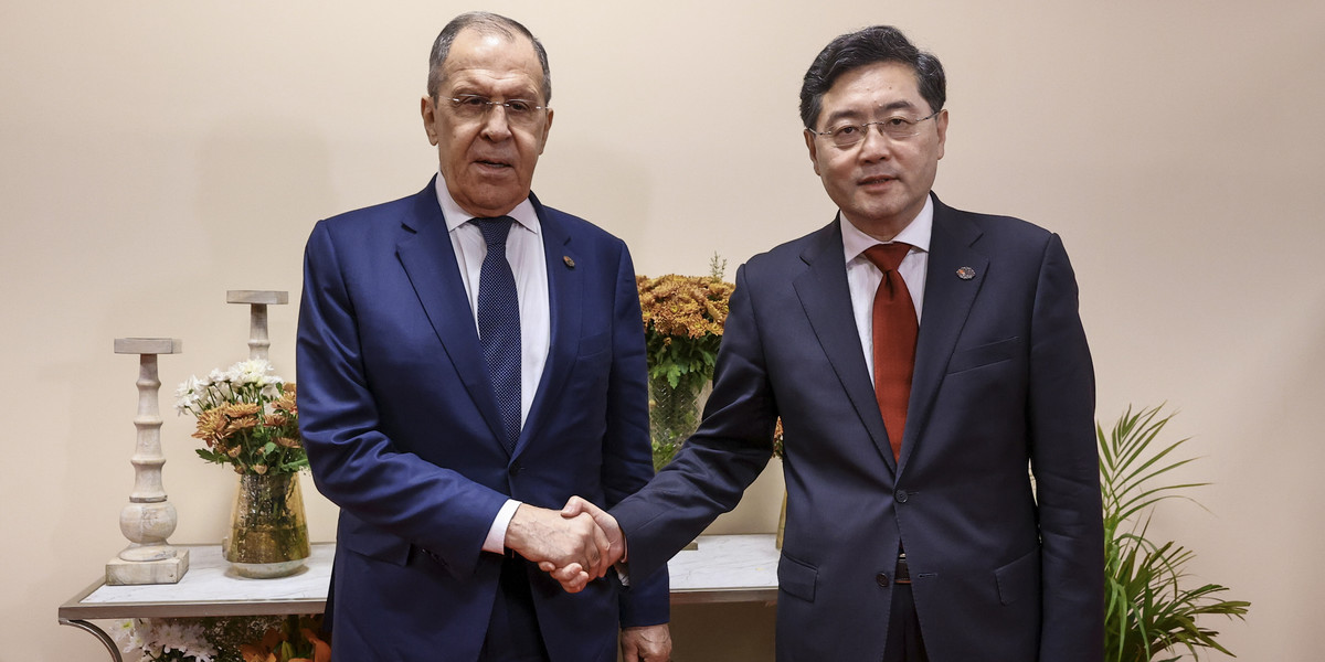 Rosyjski minister spraw zagranicznych Siergiej Ławrow podaje rękę ministrowi spraw zagranicznych Chin, Qin Gang.