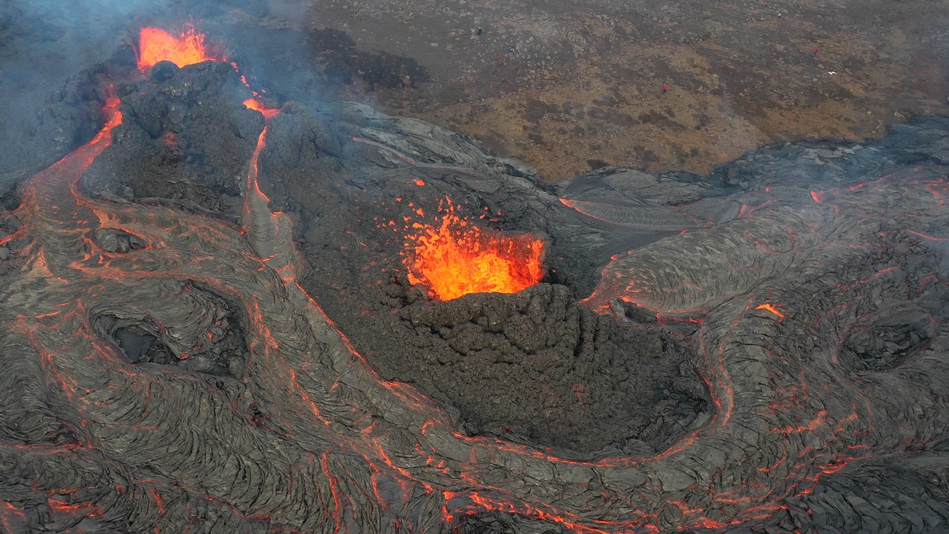 Letecký pohľad na sopečnú erupciu na Islande, pri ktorej žeravá láva preteká cez tmavé bazaltové horniny. Sopečné horniny môžu obsahovať chemické stopy materiálu pochádzajúceho z hlbokého zemského plášťa. Nová vedecká štúdia naznačuje, že vodík starý miliardy rokov môže postupne prechádzať zo zemského jadra do plášťa. (Ilustračný obrázok)