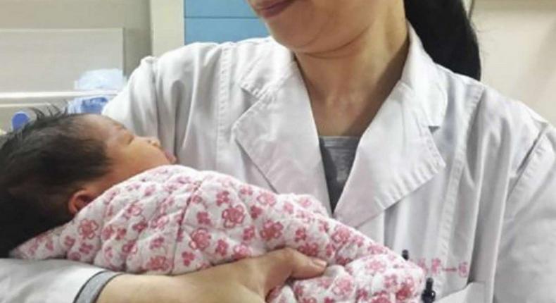 A doctor holds the healthy newborn boy at the First Affiliated Hospital of Sun Yat-sen University, in Guangdong.