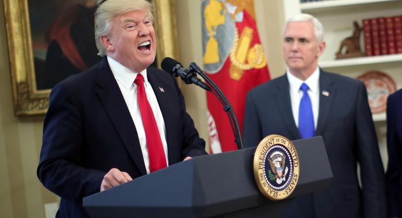 President Donald Trump speaks during a signing ceremony of executive orders on trade, accompanied by Vice President Mike Pence (C) and U.S. Commerce Secretary Wilbur Ross (2nd R) at the Oval Office of the White House in Washington, U.S., March 31, 2017.