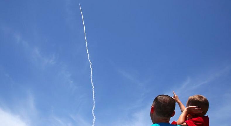 A man and a child watch as the Ground-based Midcourse Defense (GMD) system launches during a flight test from Vandenberg Air Force Base.