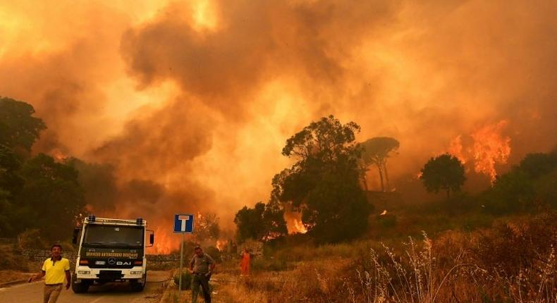 Firefighters get to work in the Annunziata district of Messina as a fire rages on July 10, 2017