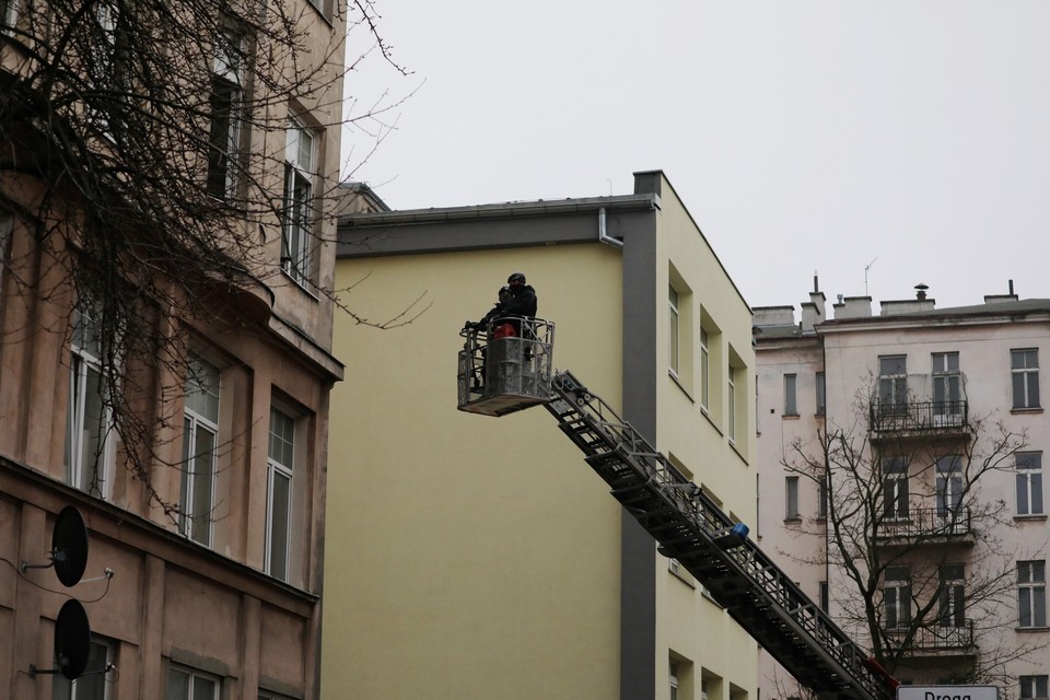 Policjanci zaglądający ze strażackiego podnośnika do mieszkania wynajętego przez działaczy Lotnej Brygady Opozycji