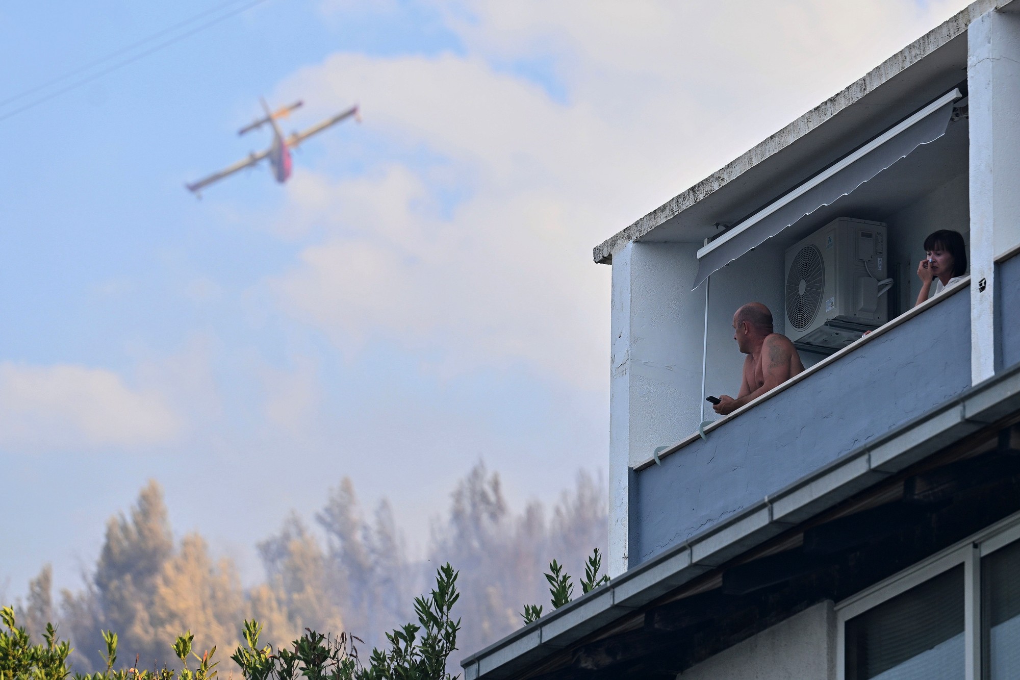 Na snímke hasičské lietadlo zasahuje počas lesného požiaru v okolí Jasenice, neďaleko obce Dugi Rat, východne od chorvátskeho mesta Split.