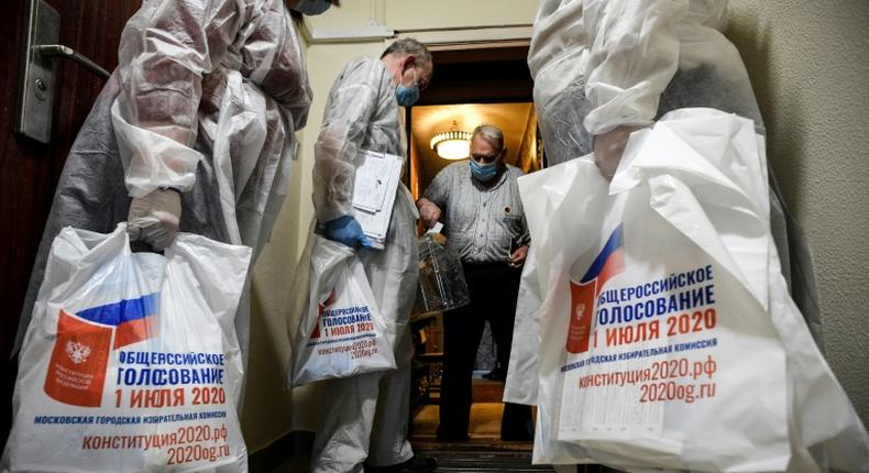 A voter casts a ballot into a mobile ballot box in Moscow during the early vote in a nationwide constitutional referendum that could extend President Vladimir Putin's term