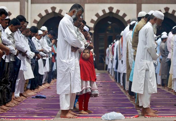 A young Muslim girl reacts as she attends the third Friday prayers of the fasting month of Ramadan i