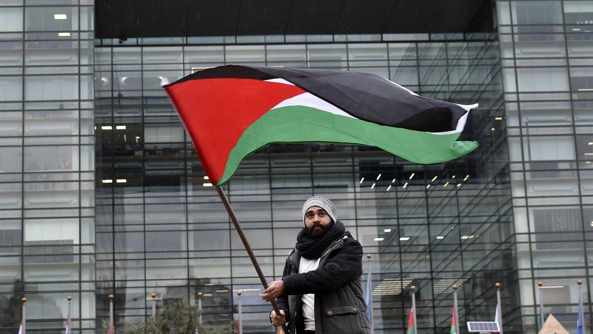 Aktywista macha flagą palestyńską podczas protestu przed siedzibą Komisji Gospodarczo-Społecznej ONZ ds. Azji Zachodniej w Bejrucie w Libanie.