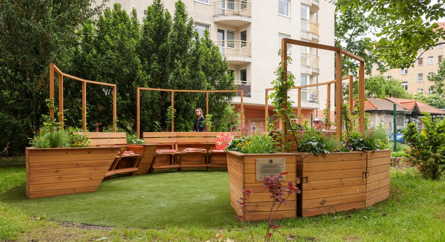 Piekna zielona pergola z miejscami do siedzenia to jeden z elementów projketu