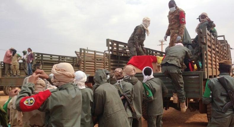 Soldiers load caskets at a funeral for victims of a suicide bomb attack at a camp in northern Gao housing former rebels and pro-government militia which killed some 77