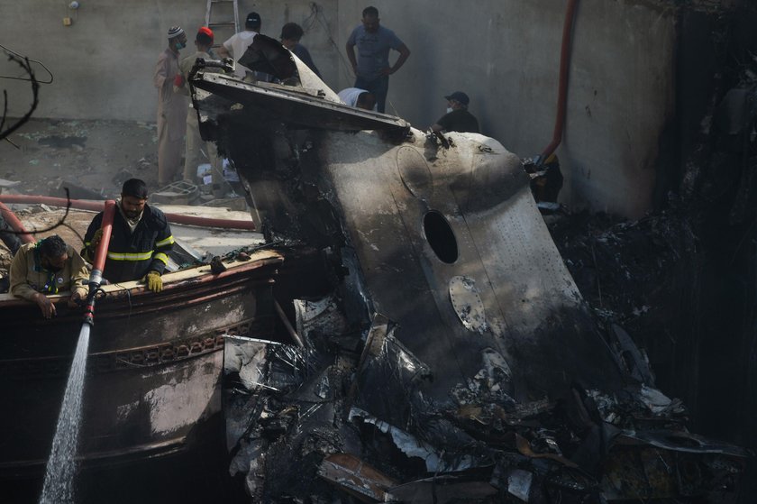 Rescue workers gather at the site of a passenger plane crash in a residential area near an airport i