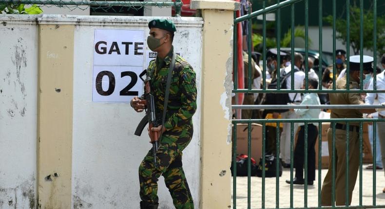 A Sri Lanka Special Task Force soldier stands guard as electoral officials collect ballot papers and boxes from a distribution centre in Colombo