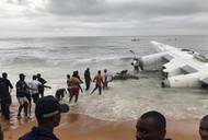 People pull the wreckage of a propeller-engine cargo plane after it crashed in the sea near the international airport in Ivory Coast's main city, Abidjan