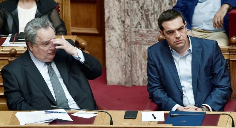 Greek prime minister Alexis Tsipras (R) and Greek foreign minister Nikos Kotzias look on during a debate on recent Cyprus talks on July 11, 2017 at the Greek parliament in Athens