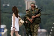 An armed man smiles at a girl