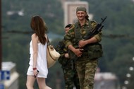 An armed man smiles at a girl