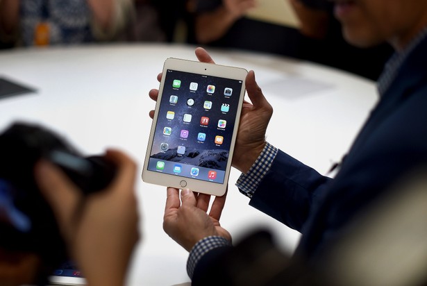 iPad Mini 3 w rękach jednego z dziennikarzy zaproszonych na prezentację nowych produktów Apple w Cupertino w Kalifornii. Fotograf: Noah Berger / Bloomberg