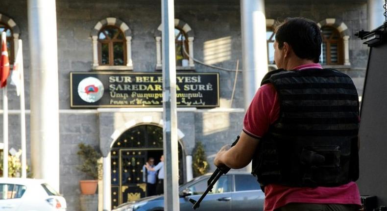 A Turkish policeman stands guard at the Sur municipality building during a police operation