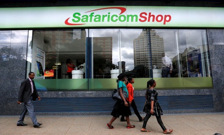 Pedestrians walk past a mobile phone care centre operated by Kenyan's telecom operator Safaricom in the central business district of Kenya's capital Nairobi, May 11, 2016.  