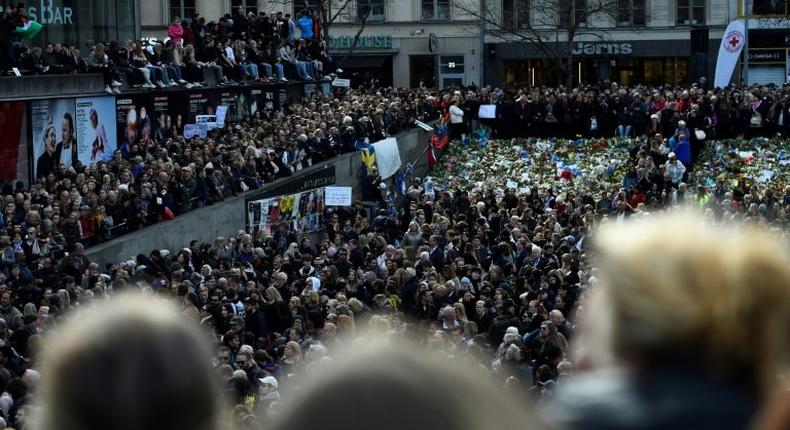 People attend a memorial ceremony on April 9, 2017 at Sergels Torg plaza in Stockholm, Sweden, close to the point where a truck drove into a department store two days before