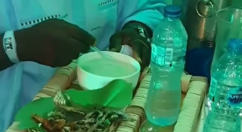 Nigerian man eating soaked gari at a party