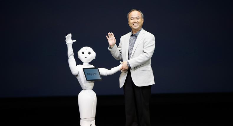 SoftBank Corp. Chief Executive Masayoshi Son (R) waves with the company's human-like robots named 'pepper' during a news conference in Urayasu, east of Tokyo June 5, 2014.