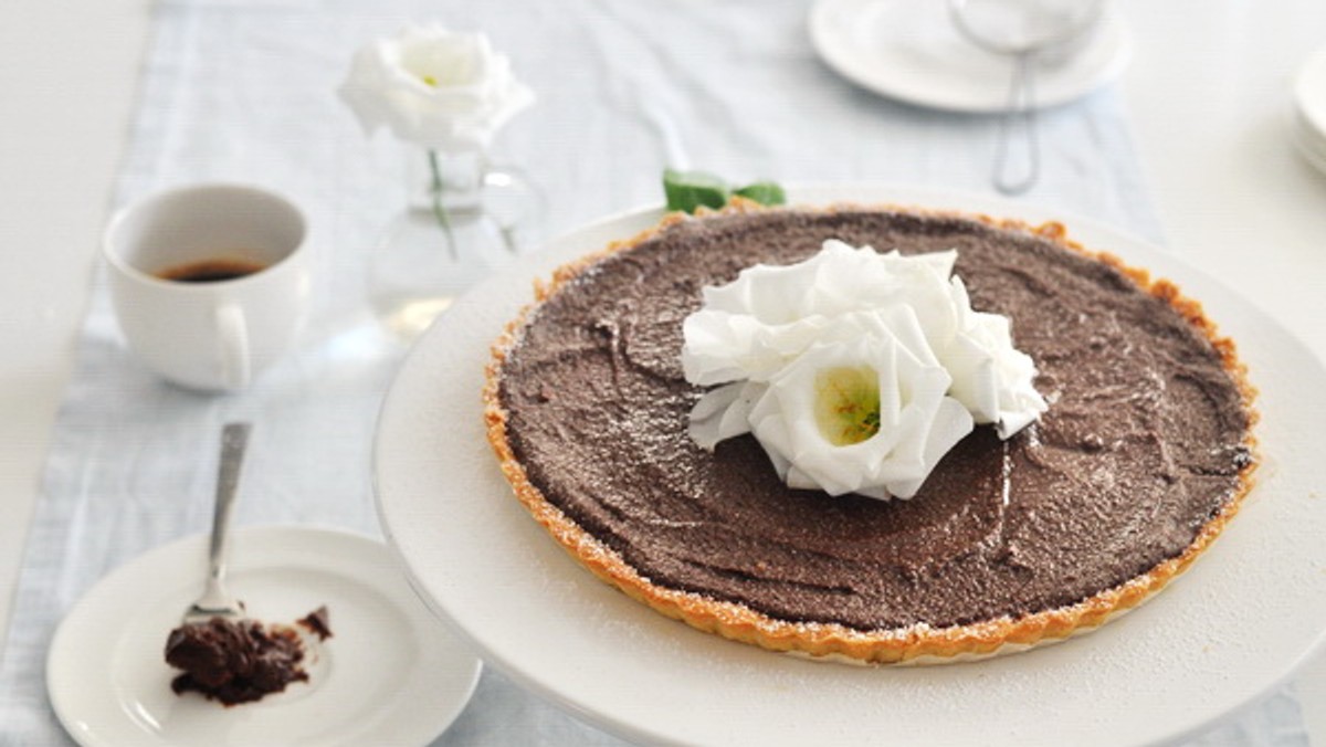 Przepyszna tarta, która pięknie się prezentuje, jest niezwykle elegancka i bogata w smaku, a co najważniejsze zaskakująco prosta w wykonaniu! Zawarte w tarcie składniki tworzą razem niesamowitą kompozycję kojącą podniebienie. Ten deser zachwyci każdego smakosza czekolady i pysznych, czekoladowych deserów.