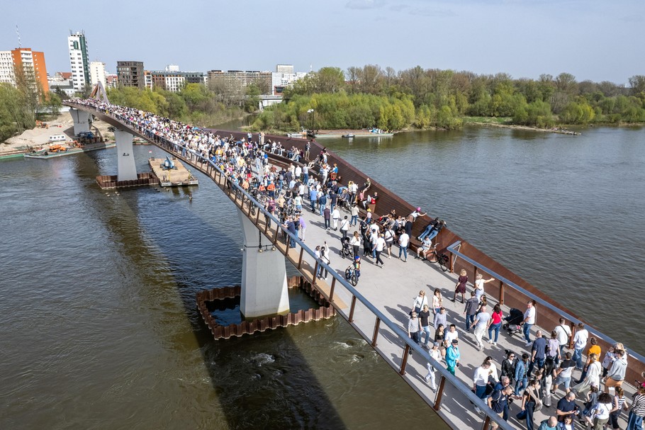 „Trwa szaleństwo związane z odwiedzaniem i przechadzaniem się przez nową kładkę pieszo-rowerową przerzuconą przez Wisłę, która ostatecznie kosztowała ok. 154 mln zł – wobec planowanych pierwotnie 121 mln zł”.