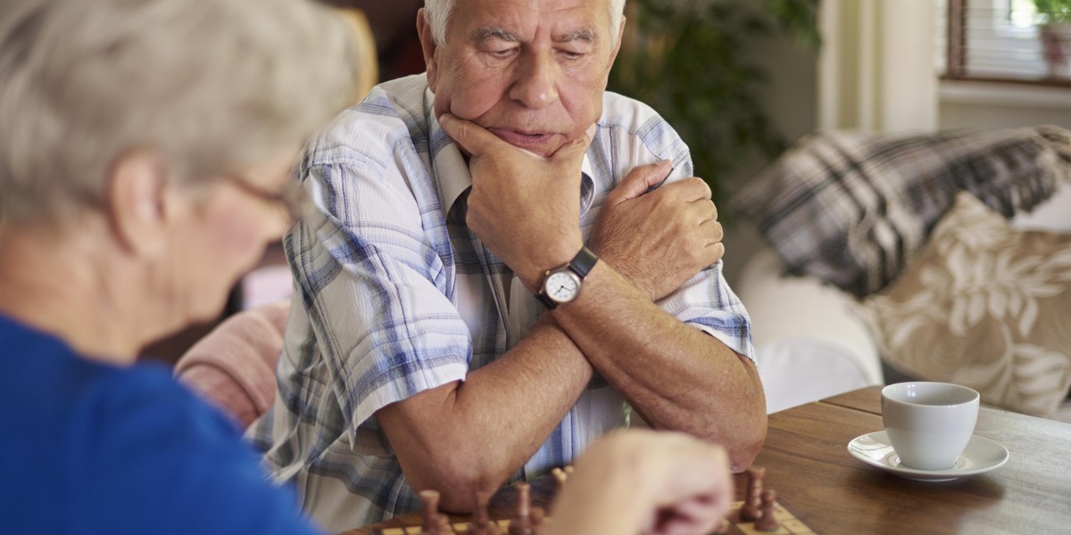 Pensive face of senior man playing chess