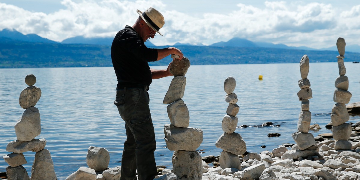 Swiss land-art artist Daniel Dunkel builds a cairn on the shore of Lake Leman in Lutry, near Lausanne, Switzerland.